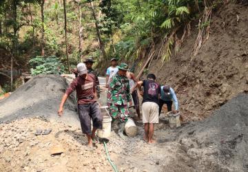 Pelda Ratam dan Warga Kompak Angkut Ember Gotong Royong Percepat Pengecoran TMMD